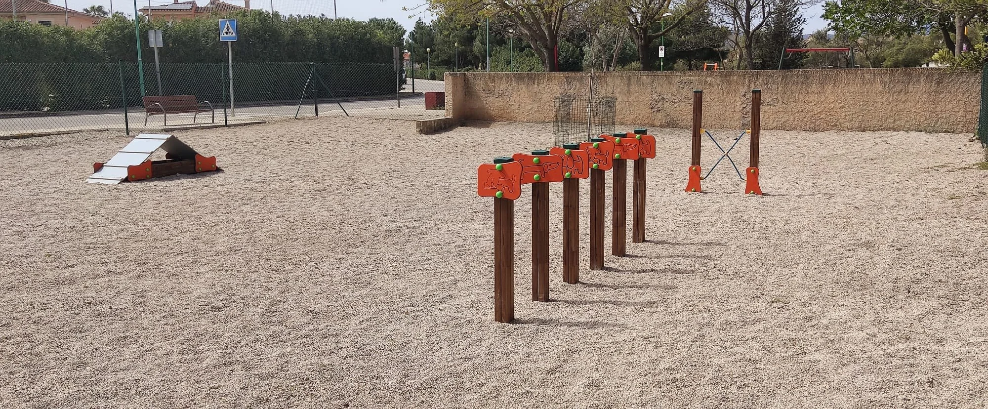 Dog park with slalom, A-frame and high jump on gravel