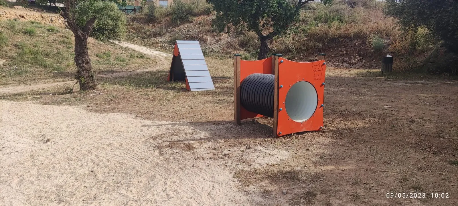Circuito de Agility con túnel naranja en terreno natural