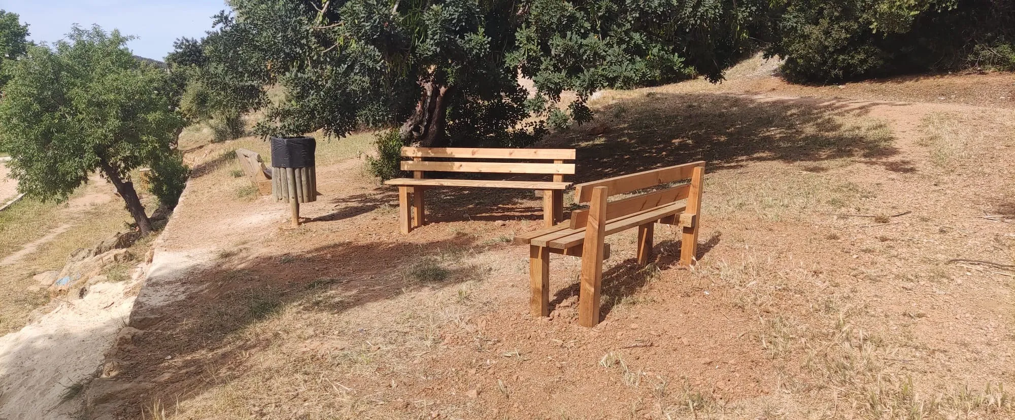 Bancos de madera y papelera recién instalados en un área natural