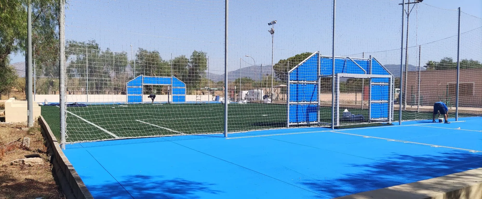 Aplicación de la pintura azul del pavimento deportivo