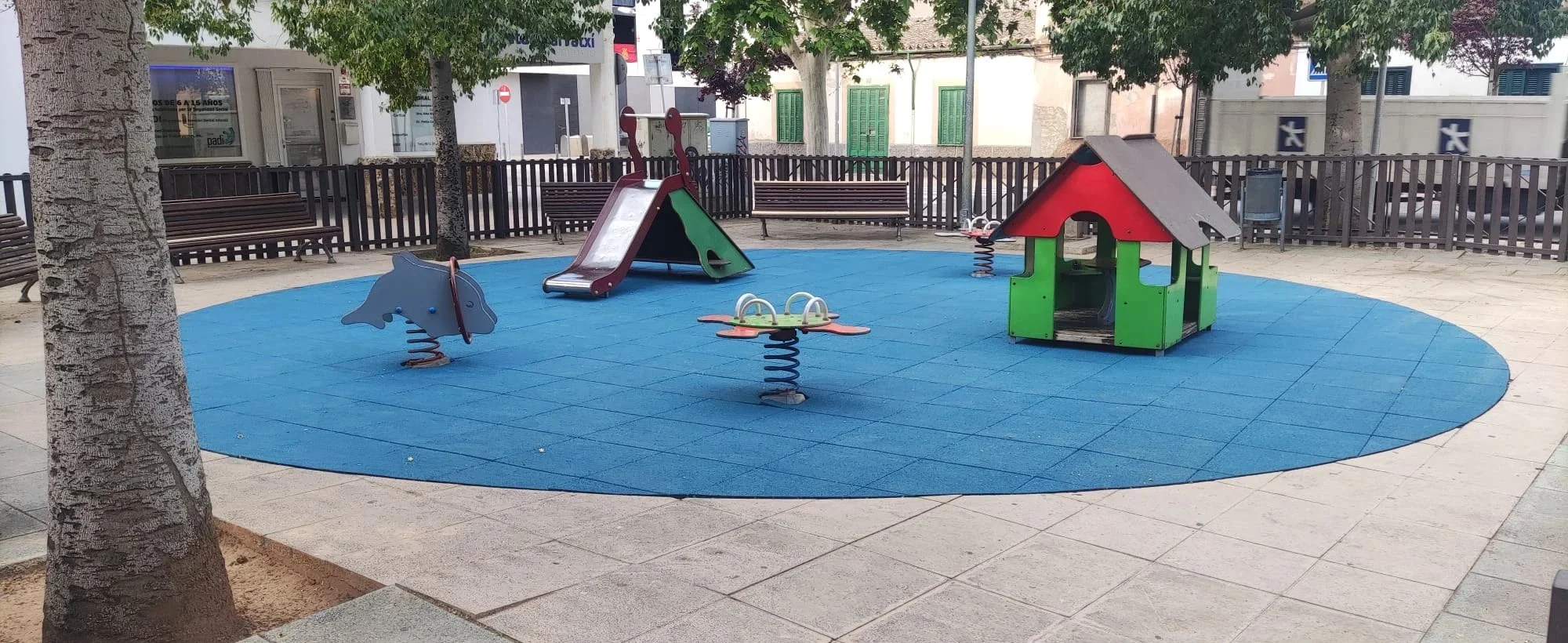 Playground with new blue rubber surfacing after renovation