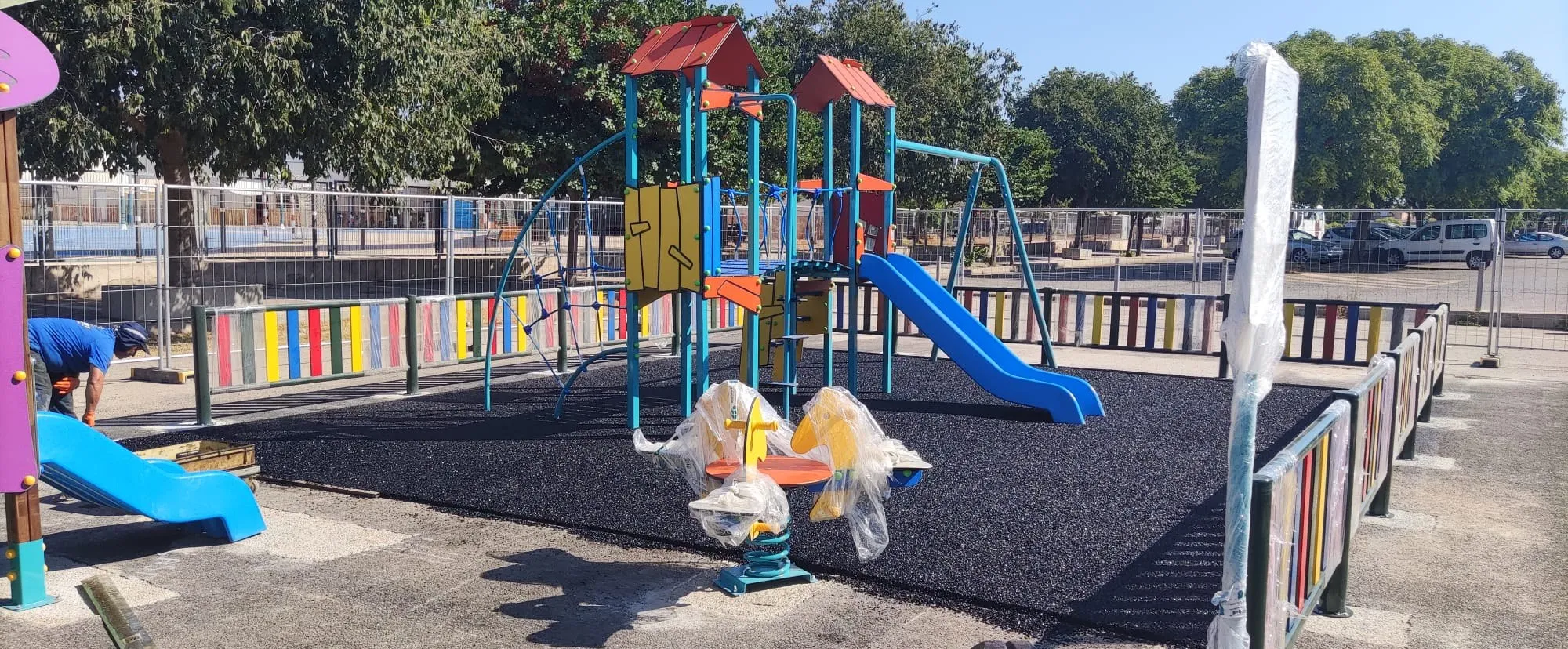 Juegos infantiles recién instalados, aún con protecciones de transporte