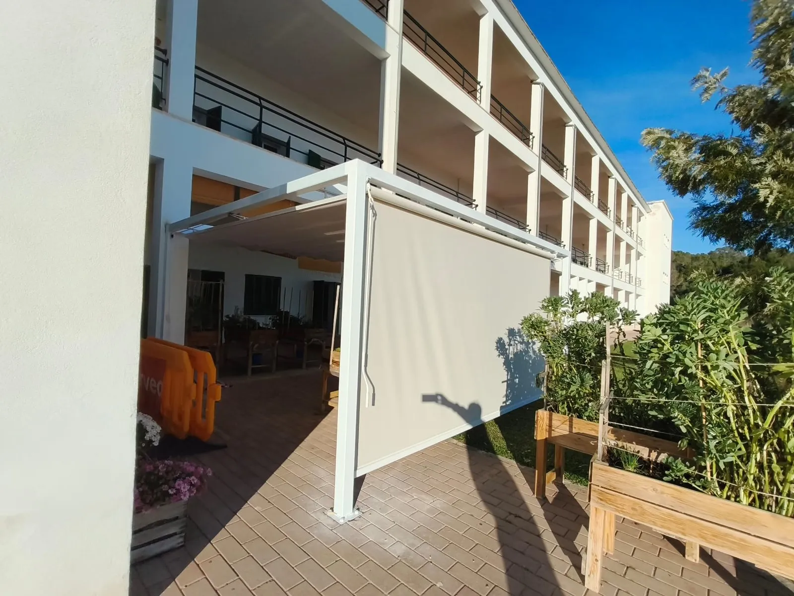 Pérgola blanca con toldo retráctil en una terraza