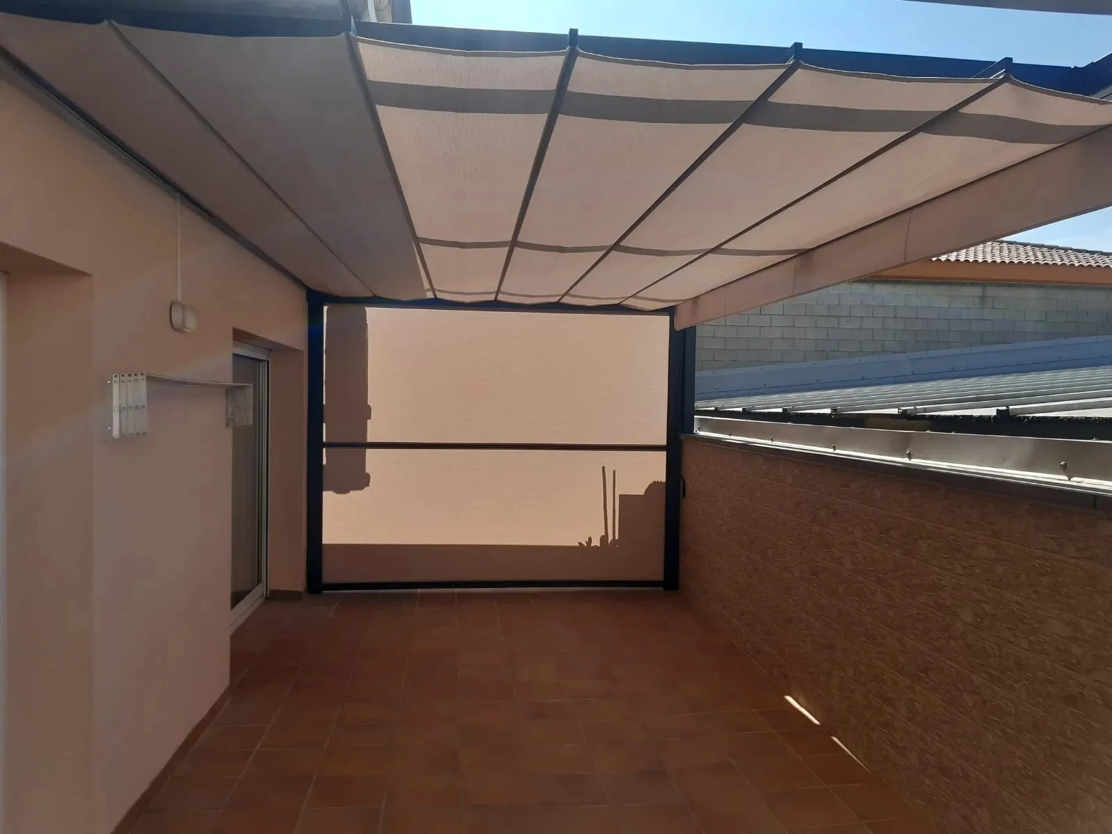 Pergola with a folding awning and a vertical screen closing off a terrace