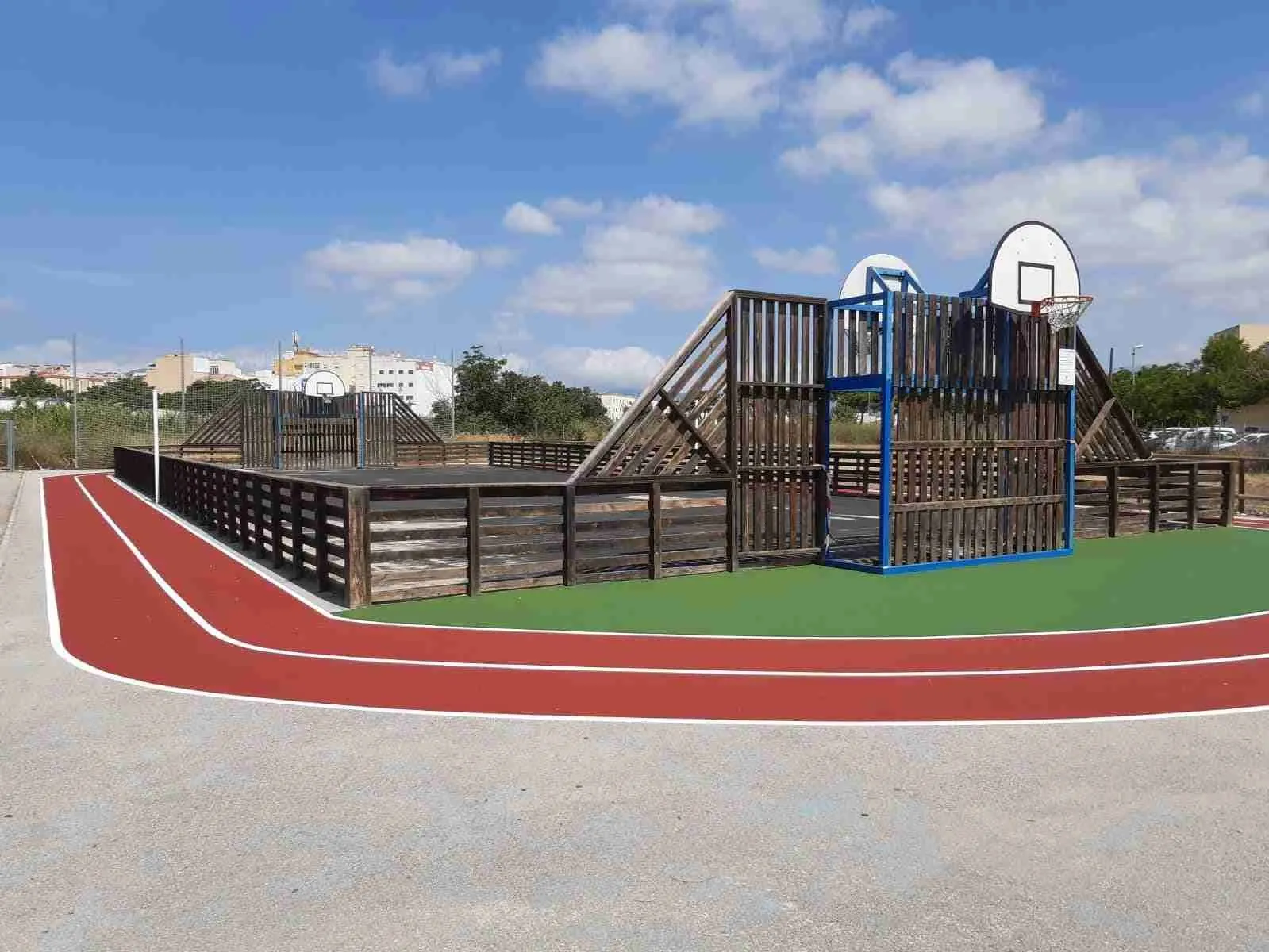 Pista polideportiva de madera con canastas y pista de atletismo