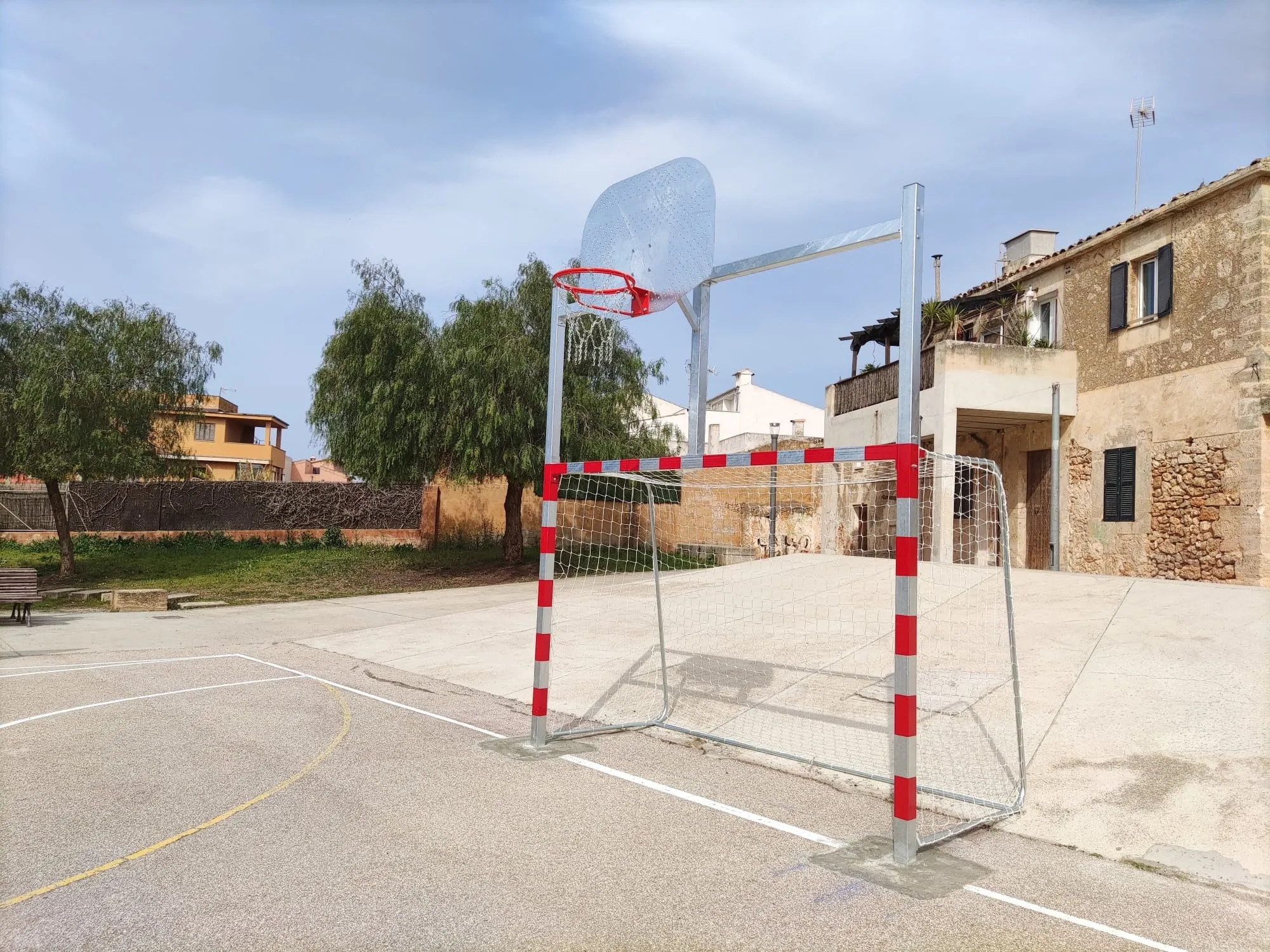 Portería de fútbol sala con canasta de baloncesto recién ancladas en una plaza