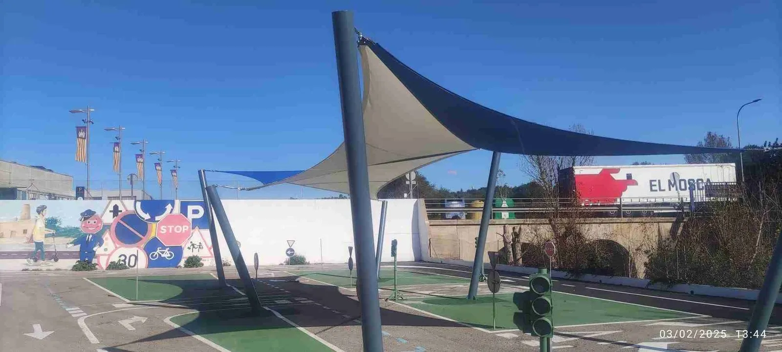 Toldo de vela azul y blanco instalado sobre una pista
