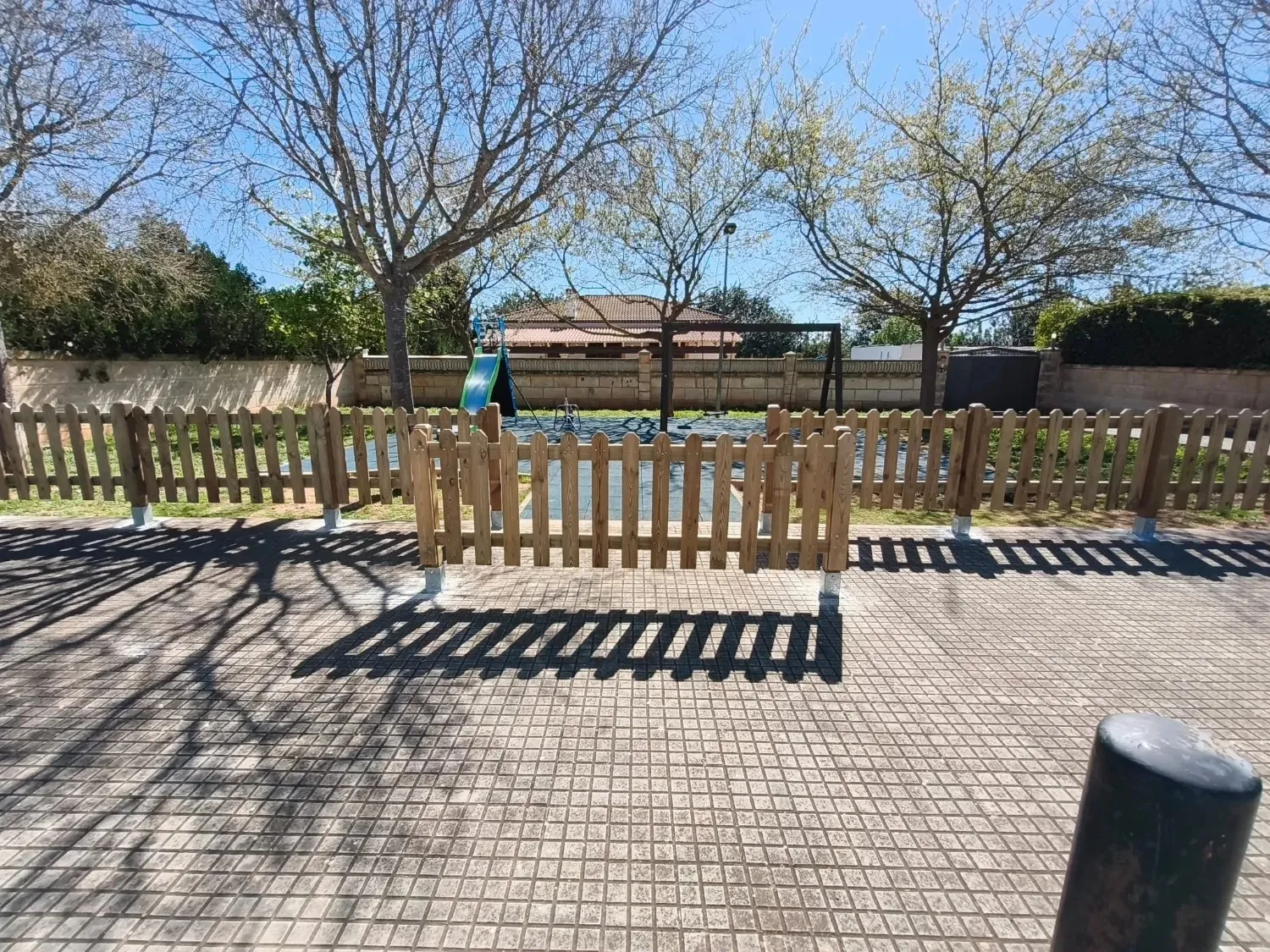 Treated timber fencing with a gate around a playground